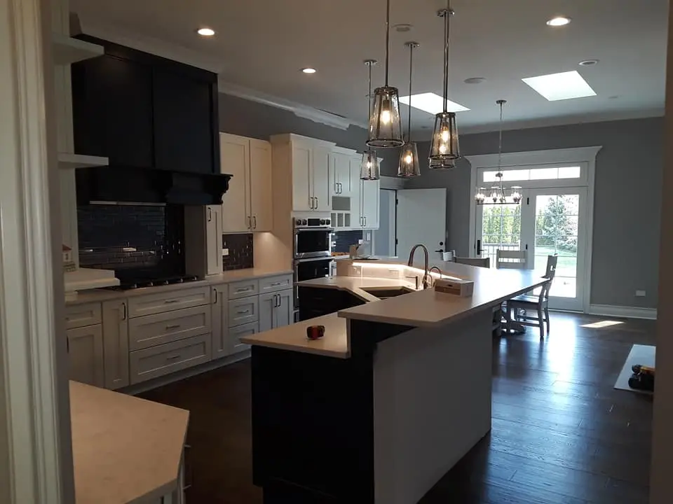 Finished kitchen with layered ceiling and island lighting