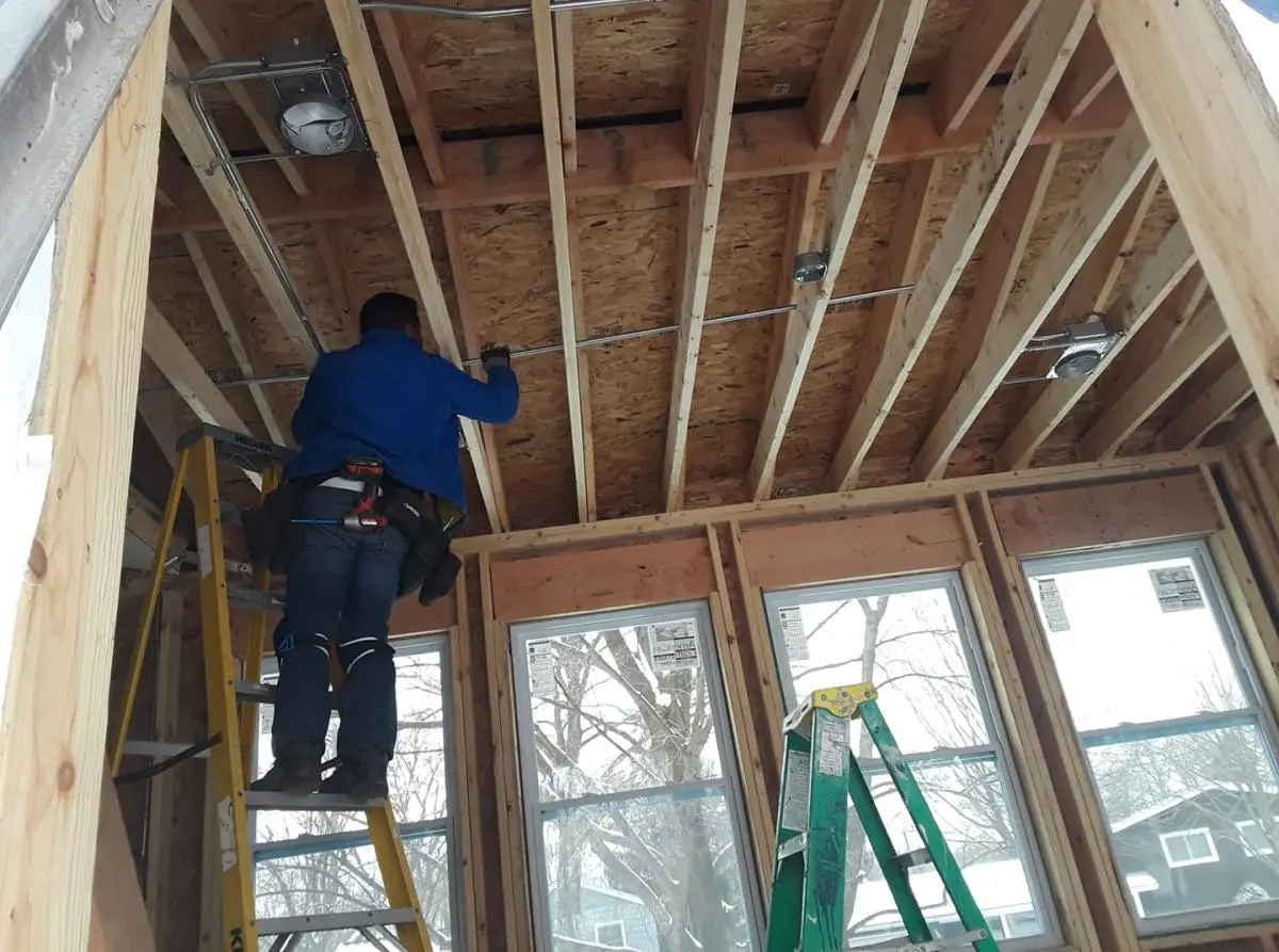 Electrician installing wiring during a residential remodel rough-in